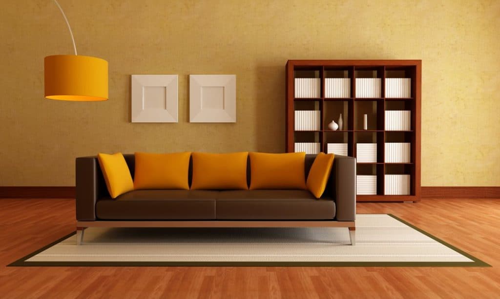 Brown couch with orange throw pillows
