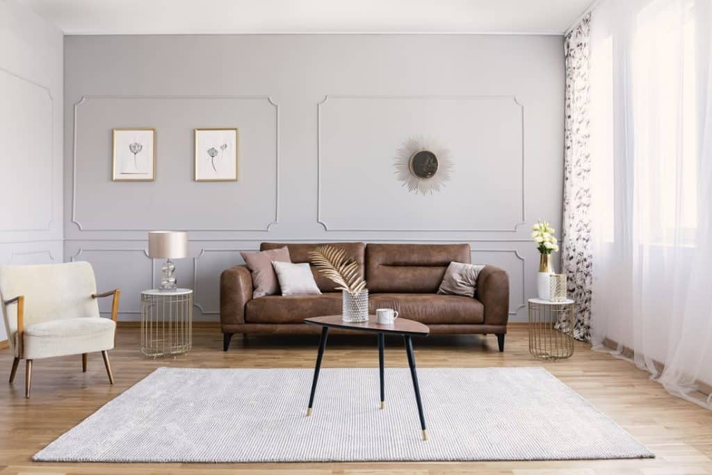 Modern living room with classic modern brown couch, throw pillows, accent chair and coffee table