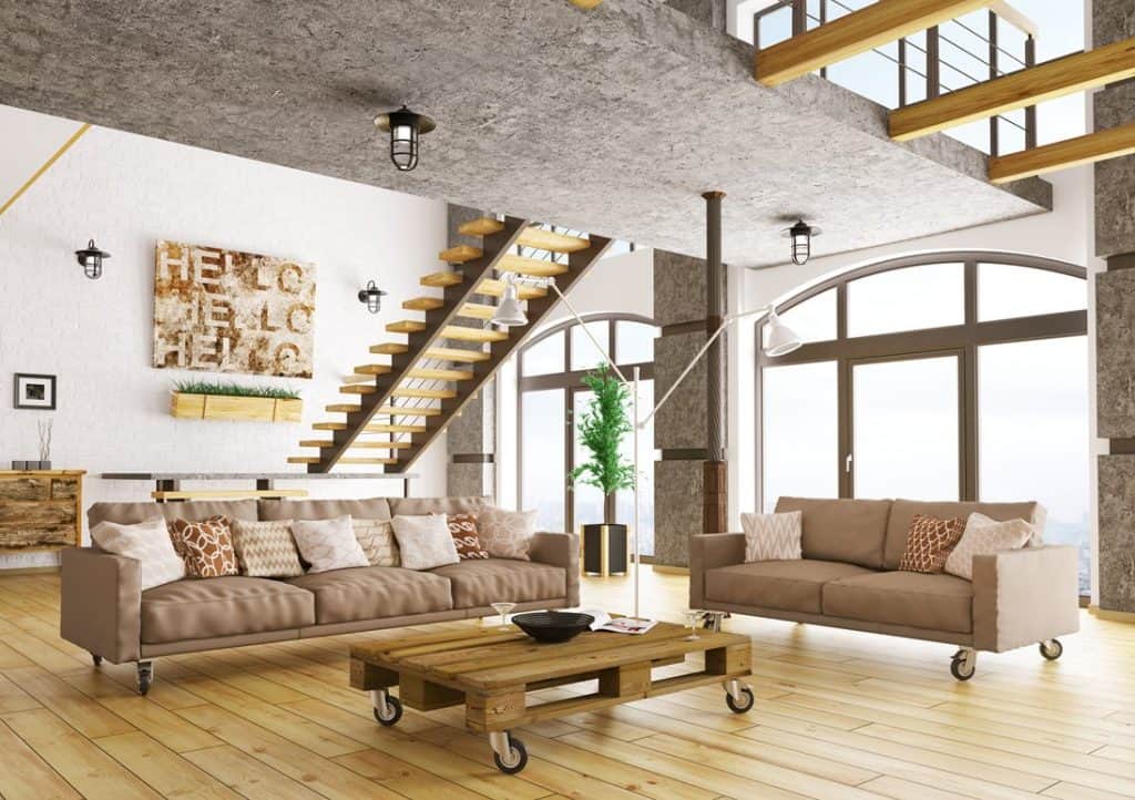 Spacious industrial touch living room with country brown couch, throw pillows, wooden table with wheels and parquet floor