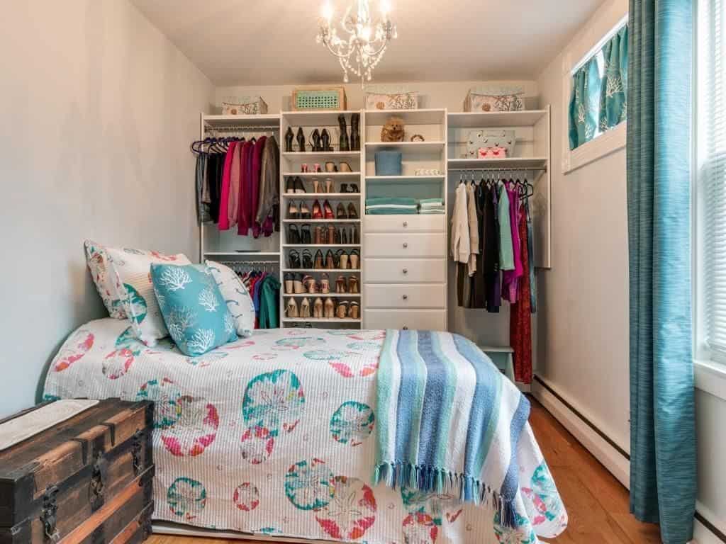 Gorgeous teal bedroom with white painted walls and cabinetry