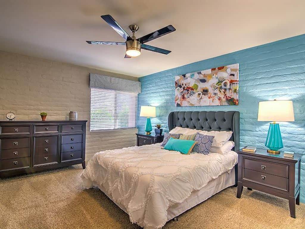 Teal and gray incorporated bedroom with a light gray accent wall and a gray bed