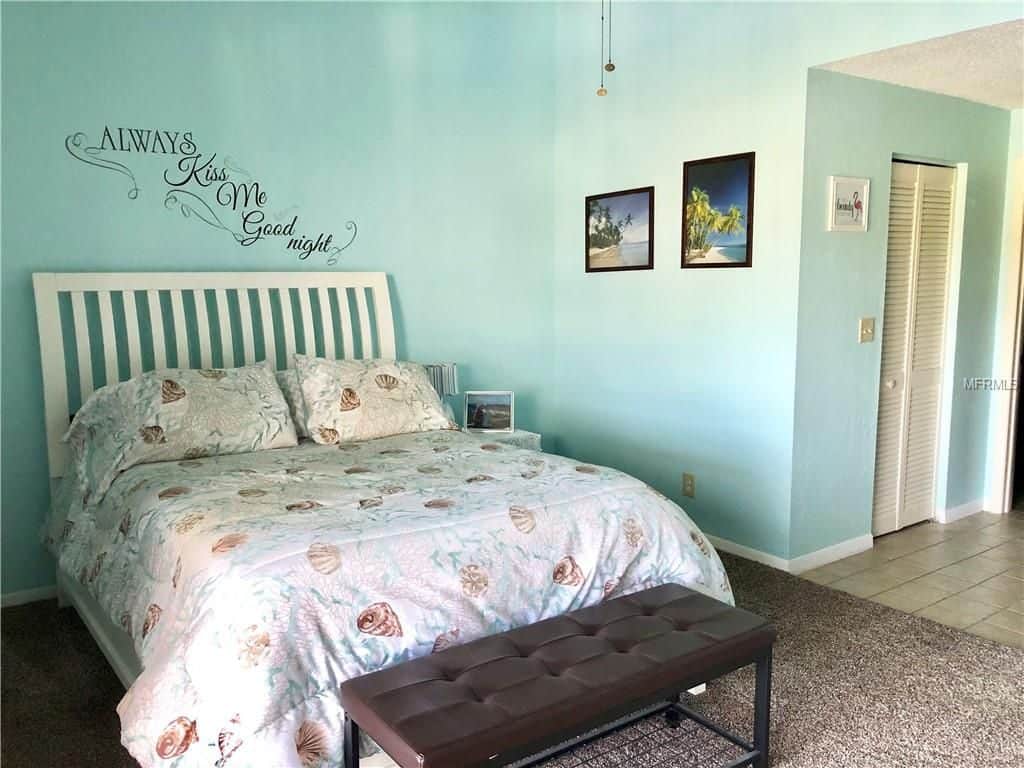 Teal painted bedroom walls with calligraphy writing on the wall