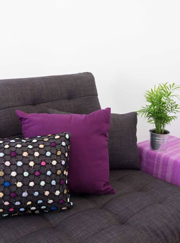 Lone Violet Throw Pillow Against Charcoal Gray | Article by HomeDecorBliss.com