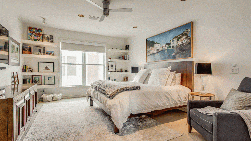 Classy white large master bedroom with a lot of picture frames and a painting