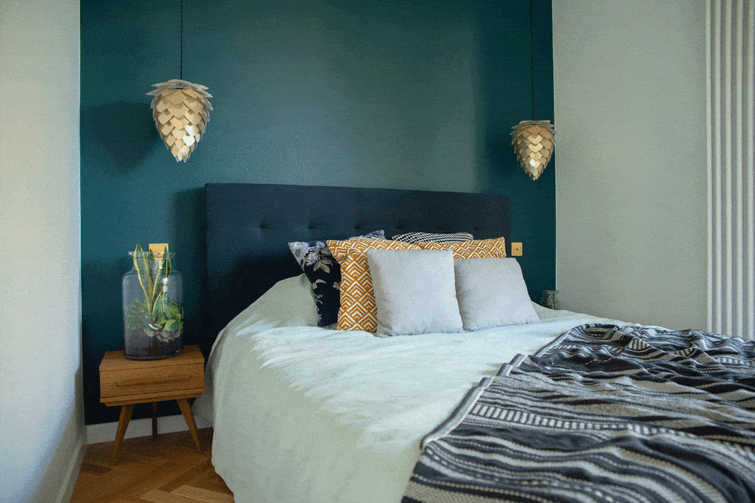 Cozy bedroom with dark teal wall and plant shaped hanging lights