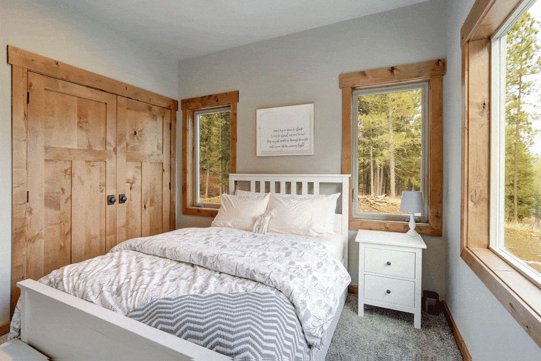 Cozy white bed with white cabinet and windows