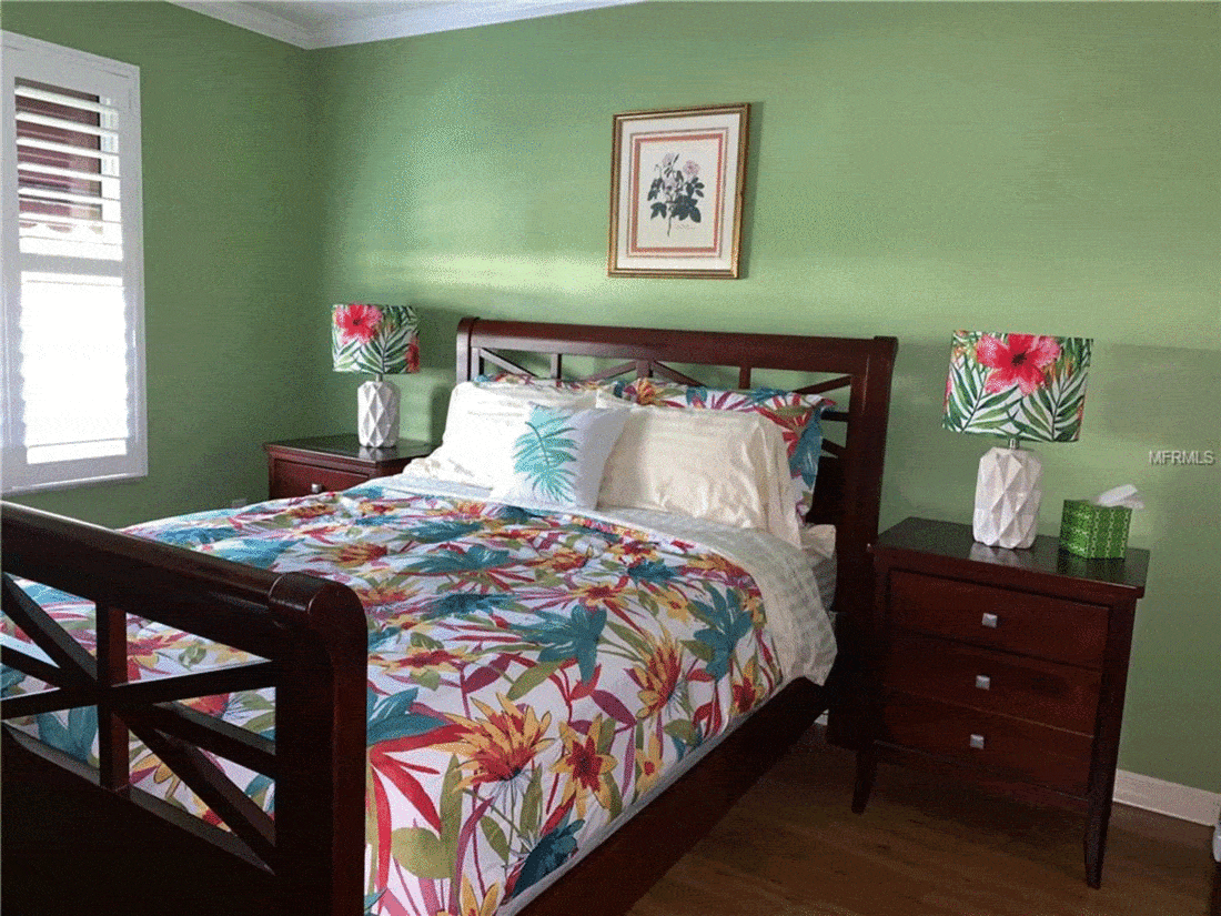 Green bedroom with colorful flower sheet
