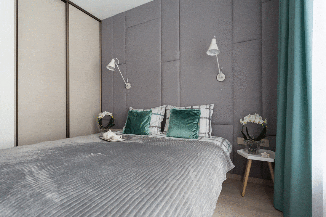 Grey bedroom with teal pillows