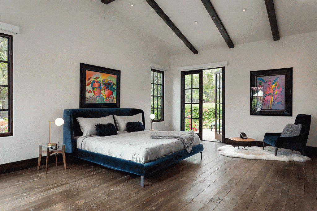 Large blue master bedroom with wood flooring