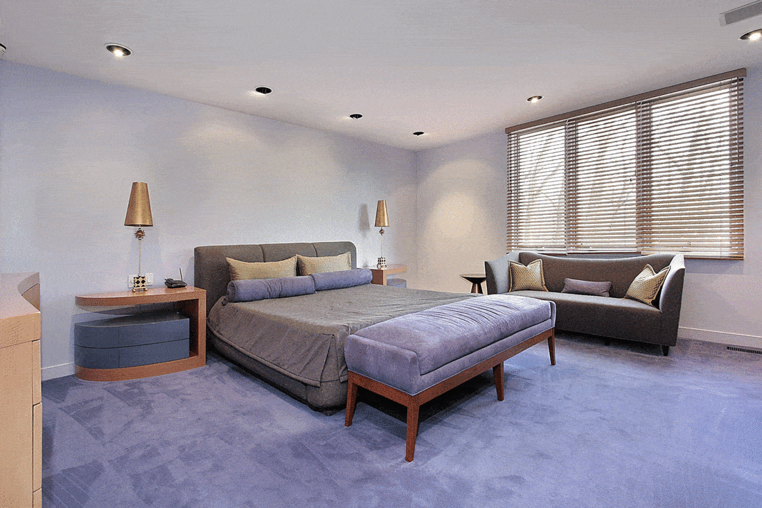 Master bedroom in luxury home with lavender carpeting