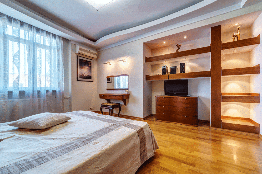 Modern large master bedroom with wooden carpet flooring