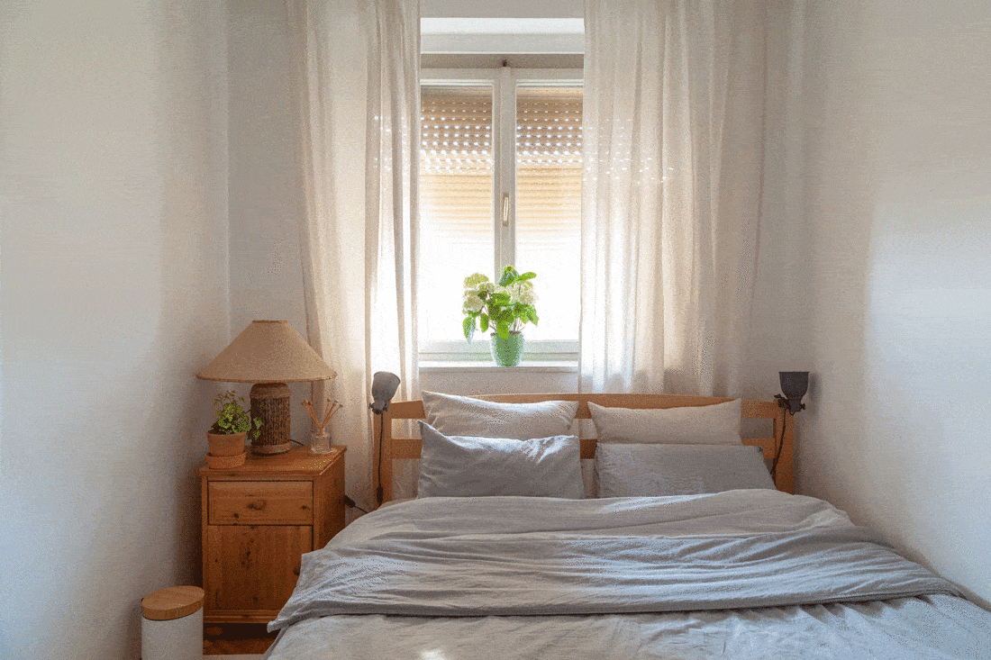 Simple bedroom with wooden interior and glass window