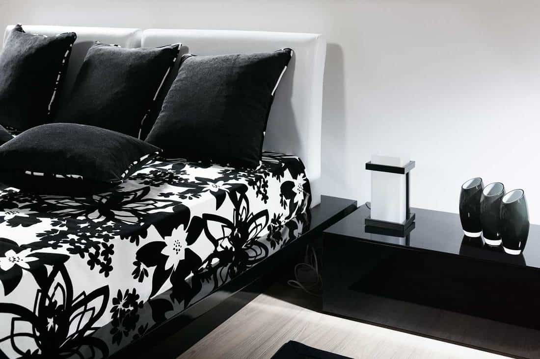 Black and white bedroom with classy modern interior, floral bed cover