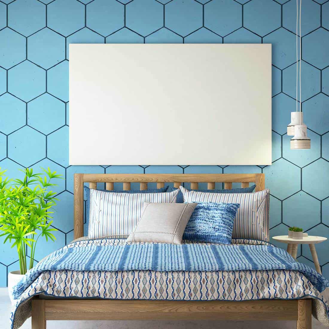 Light blue bedroom with wooden bed, patterned walls and empty frame