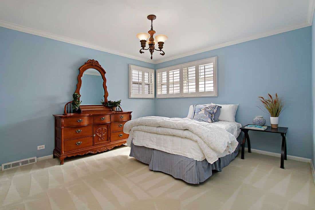 Master bedroom in suburban home with light blue walls
