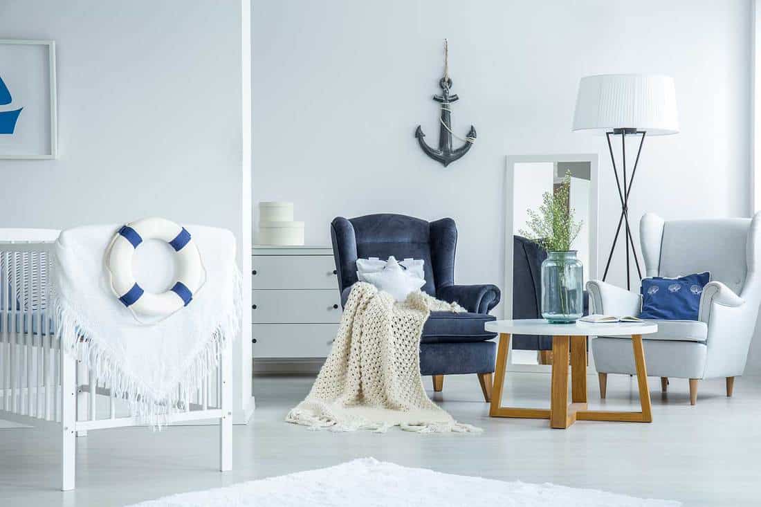 Nautical themed living room with a white baby crib with a drape