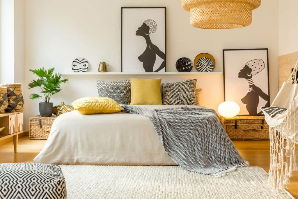 A gorgeous modern interior of a bedroom with yellow and black patterned pillows and drapes