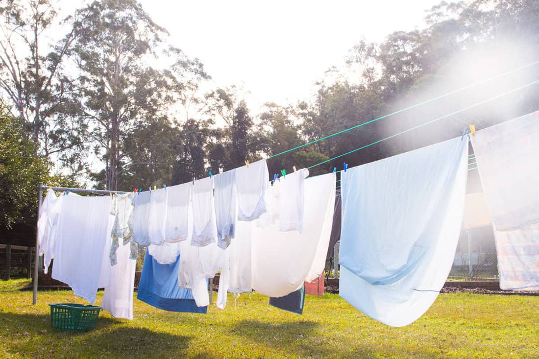 Cloths are hanging on clothesline are outside in the the direct sunlight