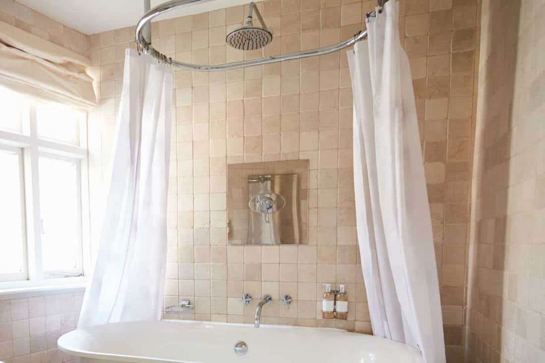 An interior of a modern bathroom with bathtub and shower curtains, Do Shower Curtains Need Liners?