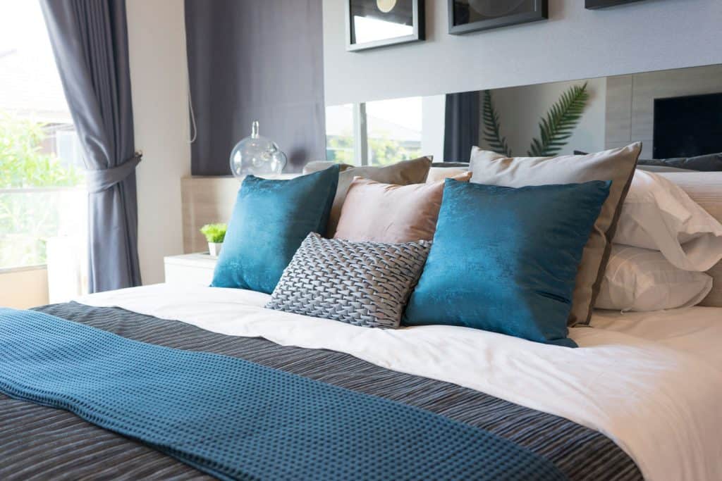 Interior of a luxurious teal and grey color themed bedroom 