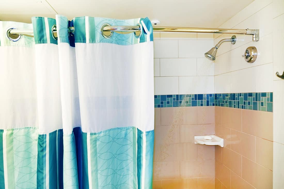 Running shower with open curtain
