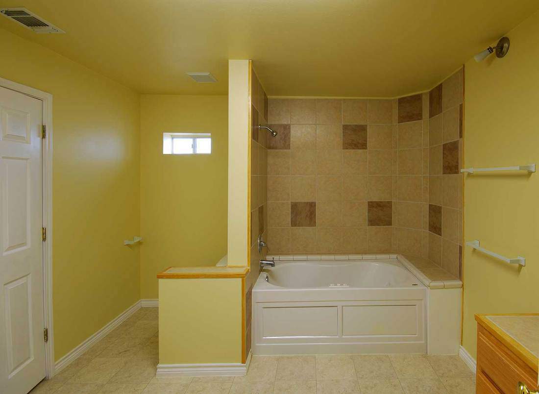 Bathroom with white tub and tiled walls