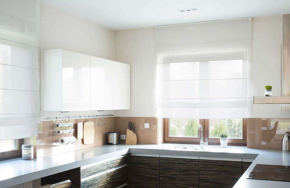 Beige kitchen interior with classy white curtain