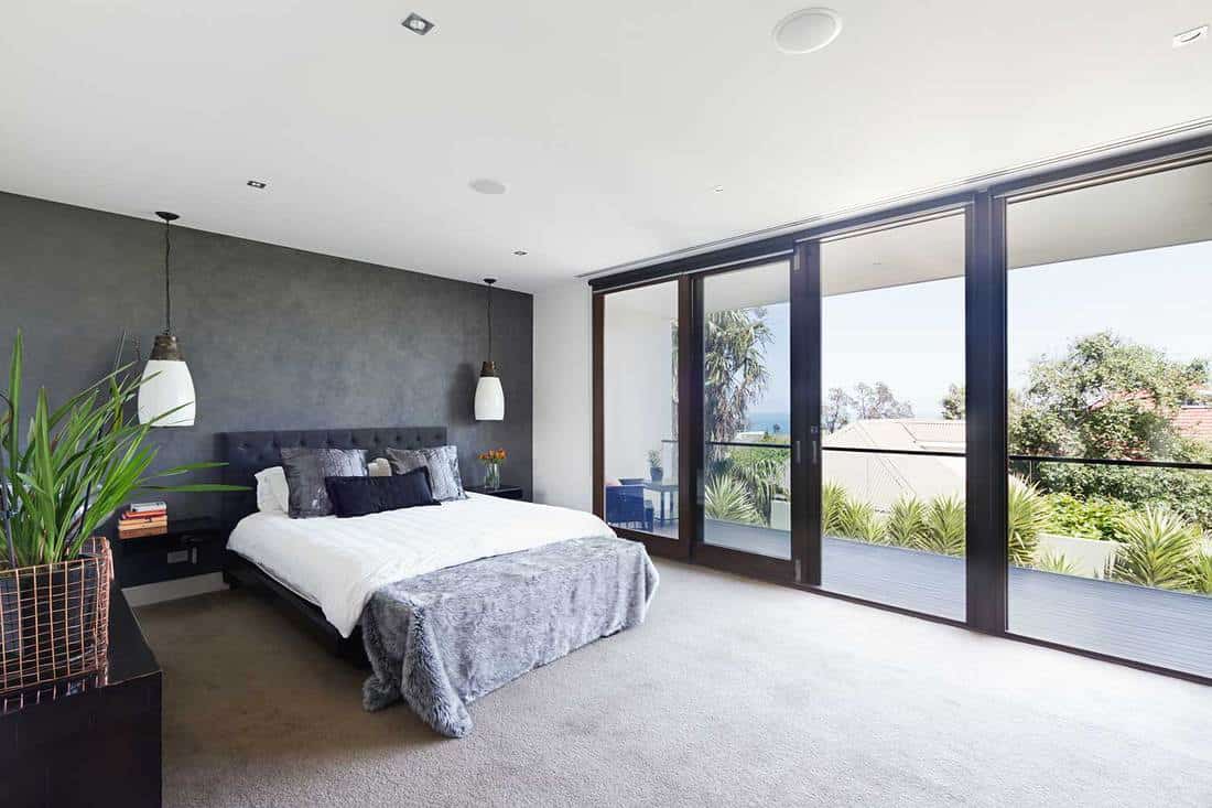 Classy modern bedroom with carpet floor and balcony