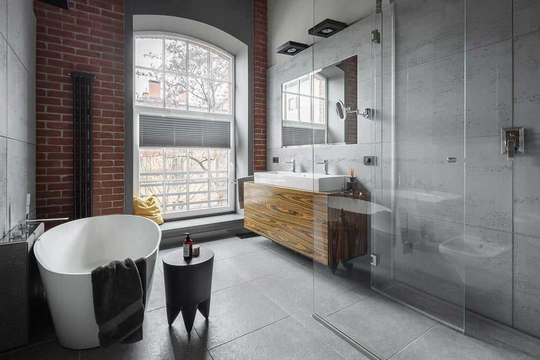 Salle de bain de style industriel avec baignoire ovale et douche à l'italienne