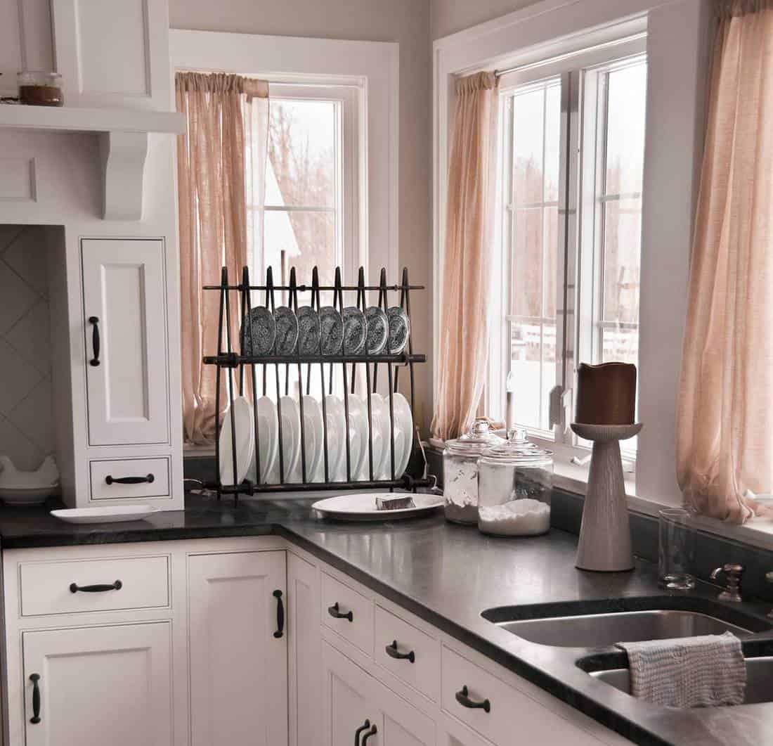 Modern black and white kitchen with peach curtain