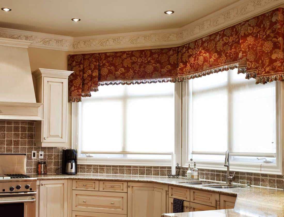 Modern kitchen interior with red floral curtain