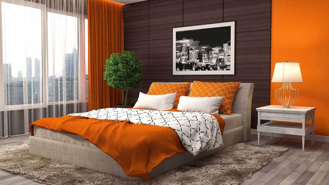 Orange bedroom with carpet and city view