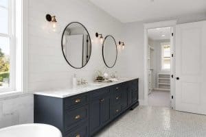 Bathroom in new luxury home with two sinks and dark blue cabinets