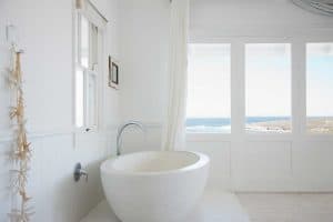 Bathtub in a white bathroom with sea view windows