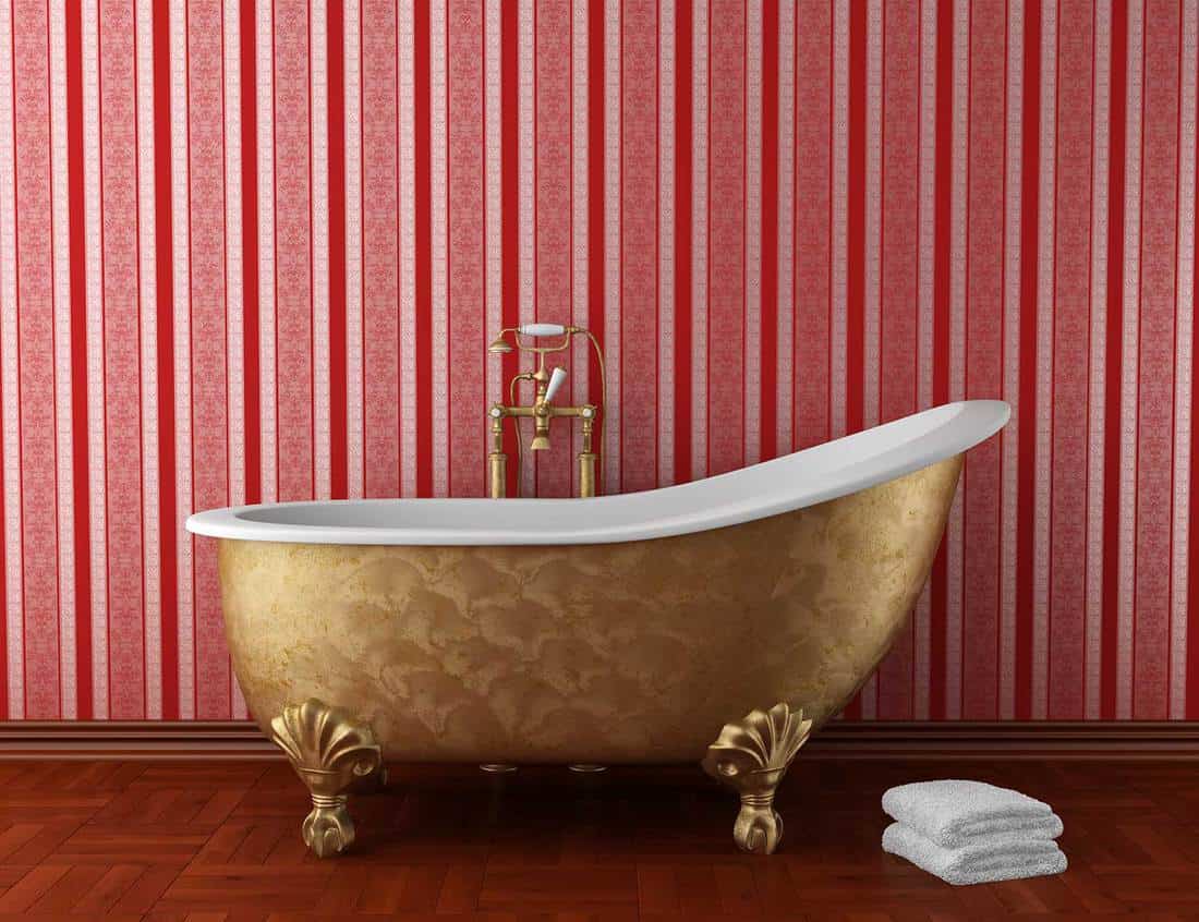Classic bathroom with old bathtub and red stripped wall