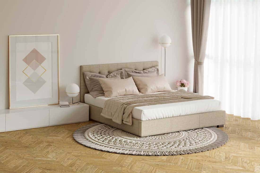 Chambre beige confortable avec photo, lampes, tables de chevet et tapis rond