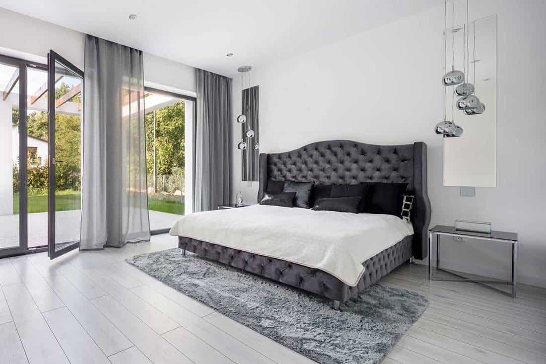 Intérieur de chambre gris de style glamour avec tête de lit matelassée du lit