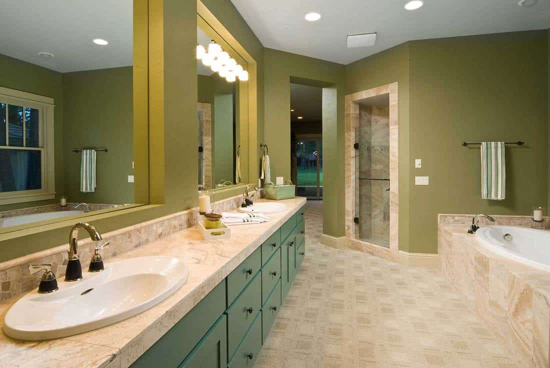 Modern bathroom with double sink, mirrors and sunken bathtub