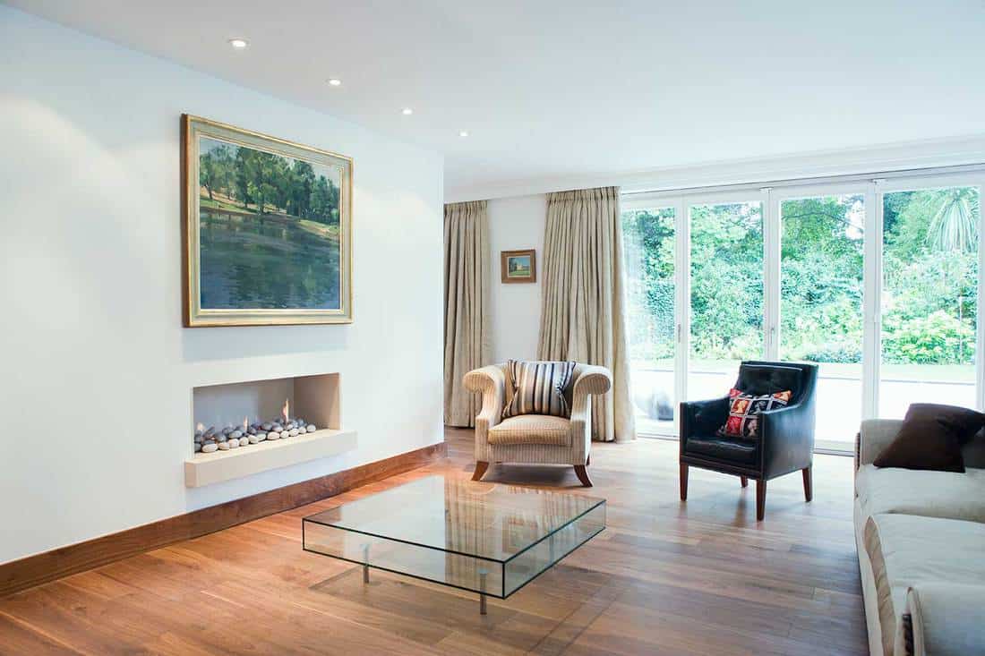 Salon moderne avec porte coulissante en verre, cheminée, canapé et table basse en verre
