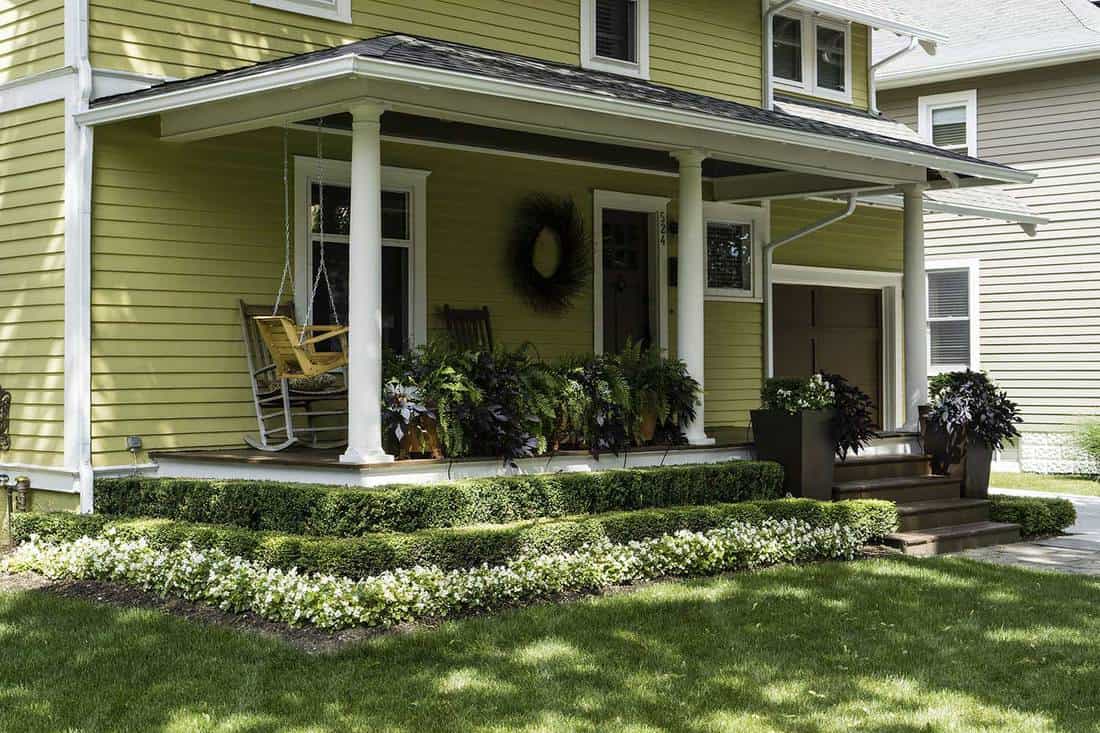 Une maison pittoresque avec porche, escalier et pelouse