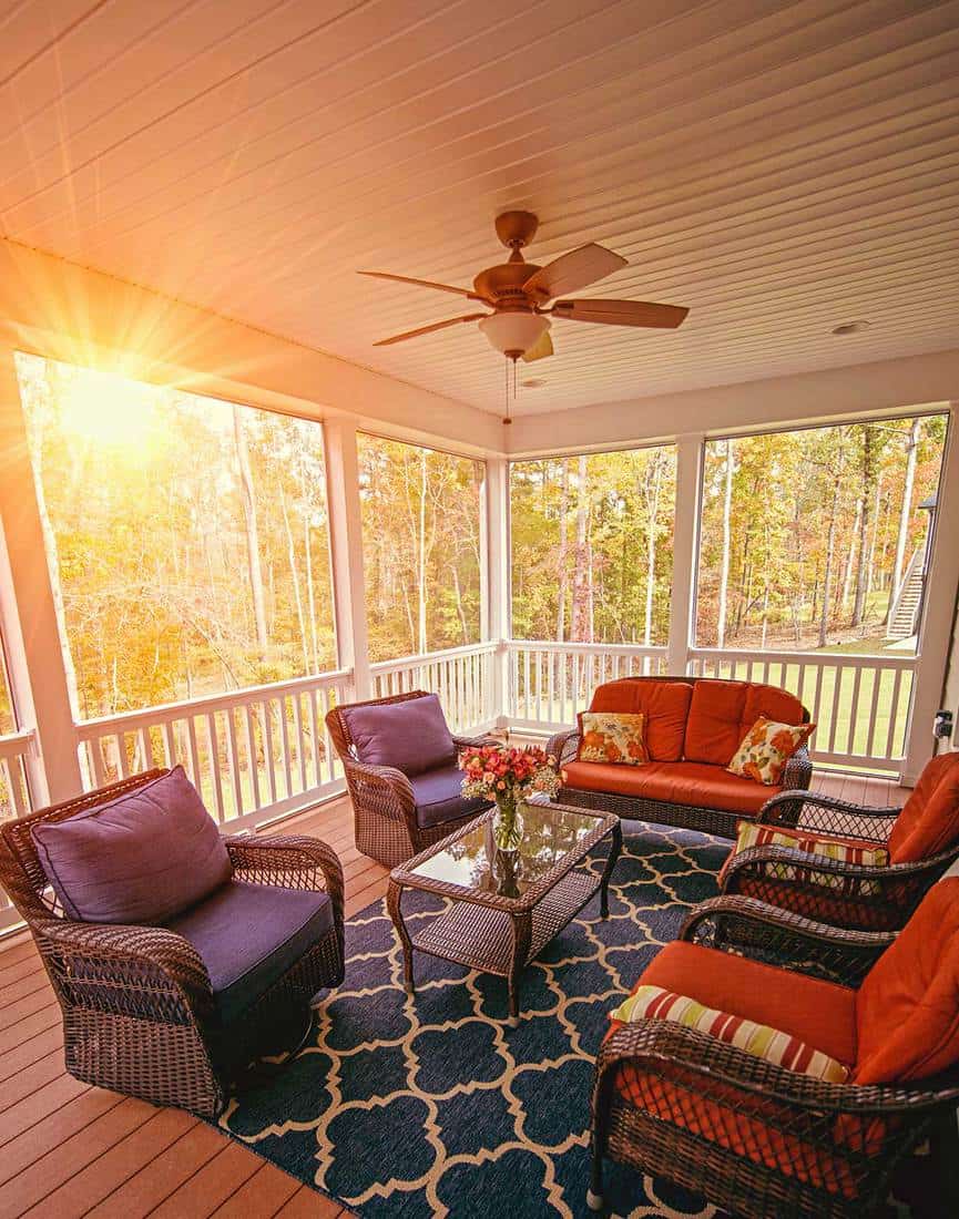 Beautiful screened in porch with cozy sofa set during sunrise