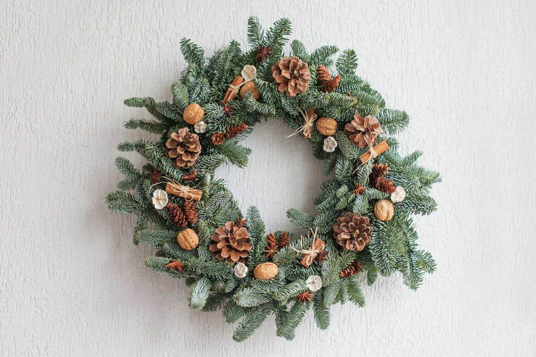 Decorative wreath with pine cones acorns and other decorative item for front door decoration, 18 Front Door Decor Ideas For Winter [Inc. images]