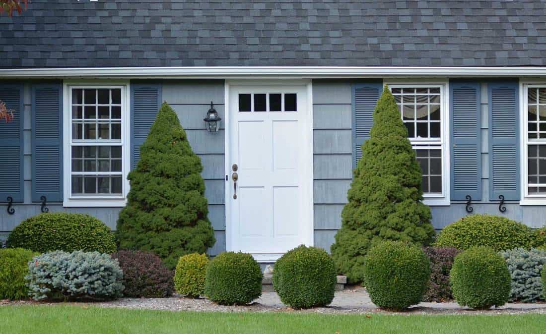Exterior of gray house with white door and landscaping