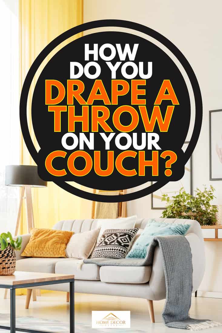 Warm living room with yellow curtains, posters and pillows on sofa, How Do You Drape a Throw on Your Couch?