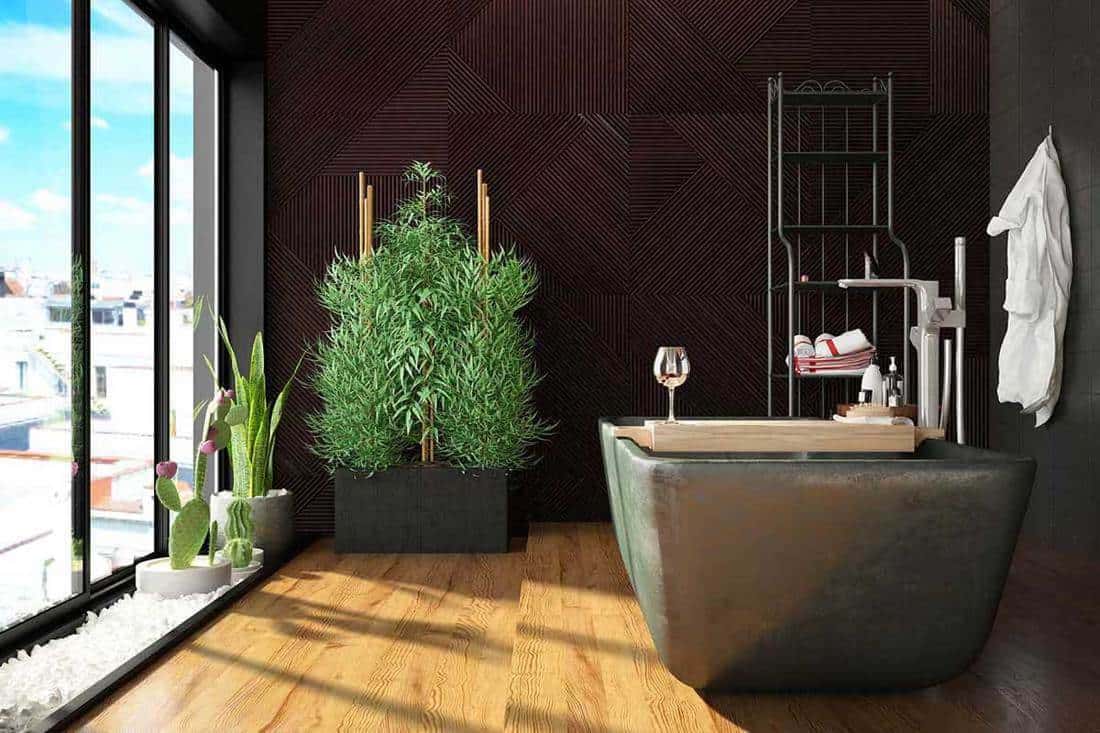 Modern bathroom with plants parquet floor and city view window