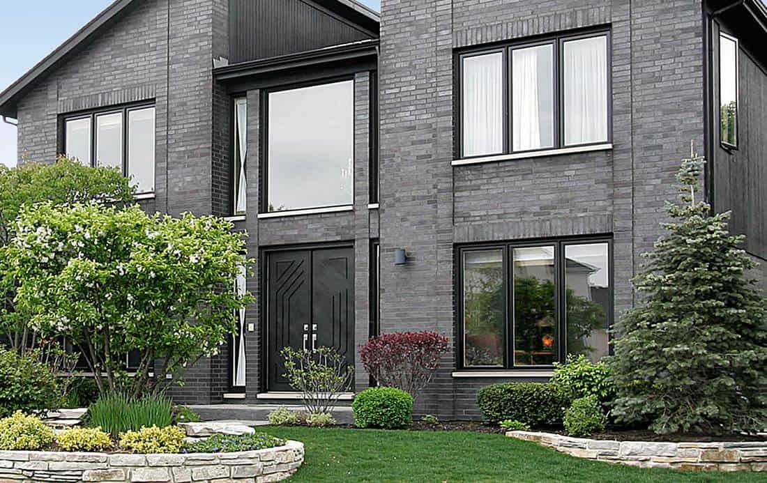 Modern home with gray brick and black door