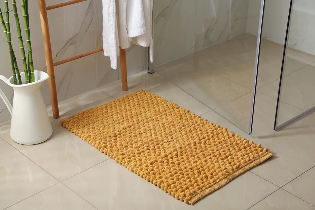 Soft orange bath mat on floor indoors