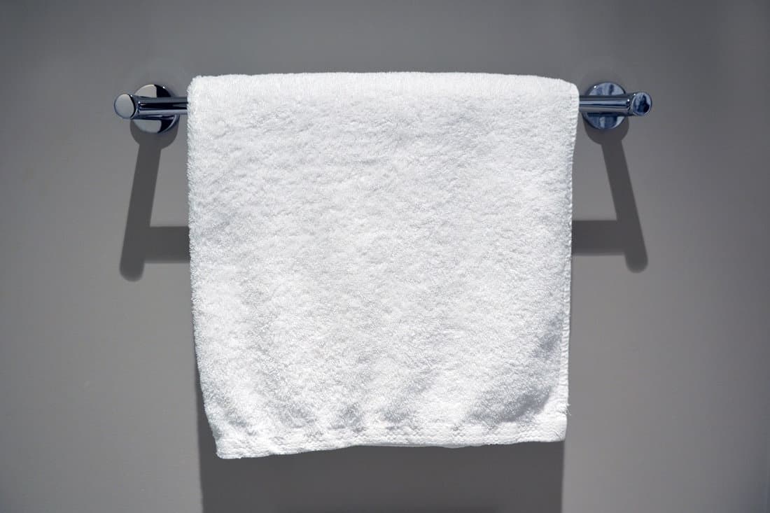 White towel hanged on a stainless steel towel rack