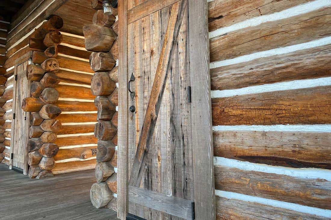 Wood log cabin building and wooden door on front porch