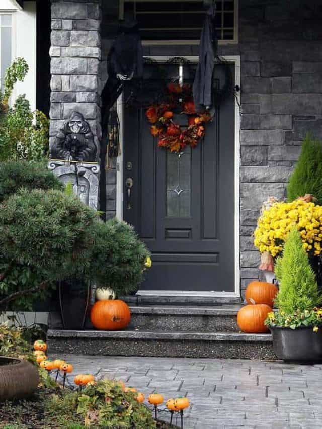 Black front door to a house decorated with Halloween pumpkins